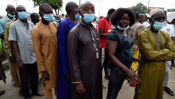 People wearing face masks queue up to vote during the Edo State governorship elections in Benin City, Midwestern Nigeria, on September 19, 2020. - Hundreds of thousand voters gathered at the polls in Edo State, Midwestern Nigeria to elect a new governor o