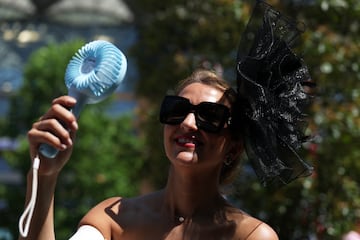 Una mujer se refresca con un ventilador port¨¢til a su llegada al hip¨®dromo de Ascot.