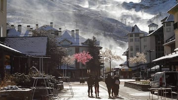 People walking with a view of Veleta peak and the ski station where the snow cannons are working after the first big snowfall of the season on November 19, 2022 in Sierra Nevada, Spain. 
 (Photo by Álex Cámara/NurPhoto via Getty Images)