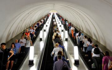 Turistas y seguidores suben y bajan las escaleras mecánicas en la estación de metro de Park Kultury en Moscú.

