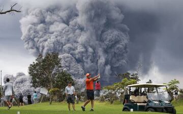 La erupción del volcán Kilauea ha dejado imágenes tan curiosas como esta de gente jugando al golf con las increíbles nubes de ceniza de fondo.