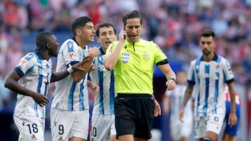 Los jugadores de la Real Sociedad protestan la decisi¨®n del ¨¢rbitro de pitar
un penalti a favor del atl¨¦tico.