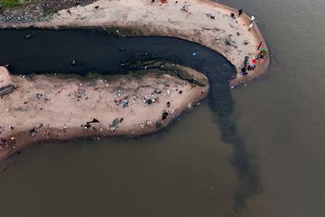 Un grupo de personas pescan junto al drenaje que desemboca en el río Paraguay en Asunción, el 28 de enero. 