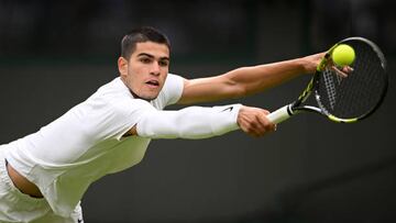 LONDON, ENGLAND - JUNE 27: Carlos Alcaraz of Spain plays a backhand against Jan-Lennard Struff of Germany during the Men's Singles First Round match during Day One of The Championships Wimbledon 2022 at All England Lawn Tennis and Croquet Club on June 27, 2022 in London, England. (Photo by Shaun Botterill/Getty Images)