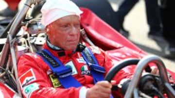 Niki Lauda sentado en el coche donde fue campe&oacute;n.