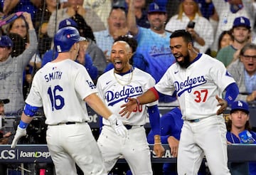 Los Angeles Dodgers catcher Will Smith (16) celebrates with outfielder Mookie Betts (50) and outfielder Teoscar Hernandez 