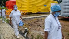 Medical staff of the Tata Memorial Centre cancer hospital walk past a temporary facility to screen patients for COVID-19 coronavirus and run outpatient department check-ups, in Mumbai on July 30, 2020. (Photo by INDRANIL MUKHERJEE / AFP)