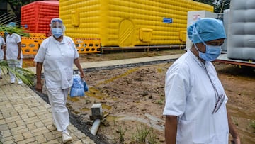 Medical staff of the Tata Memorial Centre cancer hospital walk past a temporary facility to screen patients for COVID-19 coronavirus and run outpatient department check-ups, in Mumbai on July 30, 2020. (Photo by INDRANIL MUKHERJEE / AFP)