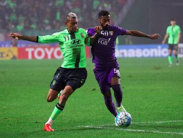 Jeonbuk Hyundai Motors' Ricardo Lopes (L) vies for the ball with Al Ain's Mohammed Fayez (R).