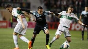 El centrocampista chileno del Celta de Vigo, Fabián Orellana (c), disputa un balón con los jugadores del Elche, Fidel (i) y Coro.