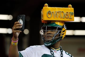 Un aficionado de los Packers que se puesto un complejo dispositivo para no escuchar cantar a Usher aprovecha para hacerse un selfie.