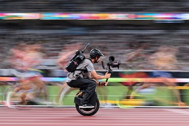 Un camarógrafo en un monociclo filma a atletas en acción mientras compiten en la final masculina de 10.000 m durante el Campeonato Mundial de Atletismo en Tokio.