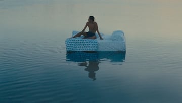 El surfista Julian Williams en un colchón sobre el agua del mar.