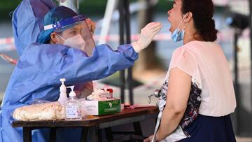 This photo taken on July 19, 2022 shows a health worker taking a swab sample from a woman to be tested for the Covid-19 coronavirus at a swab collection site in Nanning in China's southern Guangxi region. - China OUT (Photo by AFP) / China OUT (Photo by STR/AFP via Getty Images)