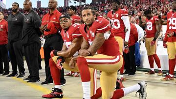 Colin Kaepernick y Eric Reid se arrodillan ante el himno y la bandera de Estados Unidos antes de un partido de los San Francisco 49ers.