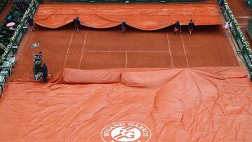 PARIS, FRANCE - MAY 22:  Ground staff cover court Phillipe Chartrier as rain delays play on day one of the 2016 French Open at Roland Garros on May 22, 2016 in Paris, France.  (Photo by Julian Finney/Getty Images)