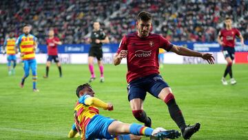PAMPLONA, SPAIN - MARCH 19: David Garcia of CA Osasuna is tackled by Marc Pubill of Levante UD during the LaLiga Santander match between CA Osasuna and Levante UD at Estadio El Sadar on March 19, 2022 in Pamplona, Spain. (Photo by Juan Manuel Serrano Arce