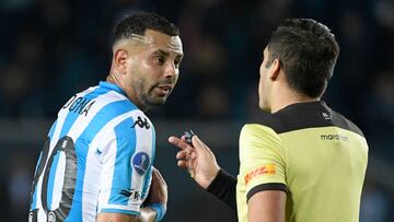 Chilean referee Cristian Garay (R) speaks with Argentina's Racing Edwin Cardona during the Copa Sudamericana group stage football match between Argentina's Racing and Uruguay's River Plate, at the Presidente Juan Domingo Peron stadium in Avellaneda, Buenos Aires province, Argentina, on May 26, 2022. (Photo by Juan Mabromata / AFP) (Photo by JUAN MABROMATA/AFP via Getty Images)