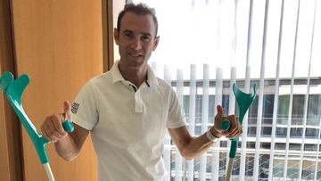 Alejandro Valverde posa de pie con unas muletas en el Hospital de Düsseldorf.