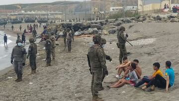 GRAF040. CEUTA, 18/05/2021.- Miembros del Ej&eacute;rcito observan a un grupo de inmigrantes que ha llegado a nado en los espigones fronterizos de Ceuta este martes en una avalancha de inmigrantes sin precedentes en Espa&ntilde;a al registrarse la entrada