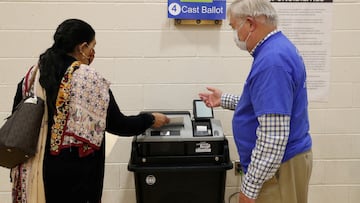 FILE PHOTO: A woman, who preferred not to give her name, gets verbal instructions from an Election Officer as she casts her ballot at a polling place at the Randolph Elementary School in Arlington, Virginia, U.S., November 2, 2021. REUTERS/Leah Millis/File Photo
