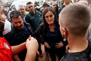 La reina Letizia de España escucha a la gente mientras tiene barro en la cara, tras las fuertes lluvias que provocaron inundaciones, en Paiporta.