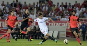 El delantero del Sevilla FC Denis Suárez centra el balón entre Esteban Granero y Jon Gaztañaga, de la Real Sociedad, durante el partido de la quinta jornada de Liga de Primera División que se disputa esta noche en el estadio Sánchez Pizjuán, en Sevilla. 