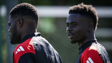 Arsenal's English midfielder #07 Bukayo Saka (R) reacts as he arrives to take part in a training session at the Arsenal Training centre in Shenley on April 7, 2025, on the eve of their UEFA Champions League Quarter final first leg football match against Real Madrid. (Photo by Adrian Dennis / AFP)