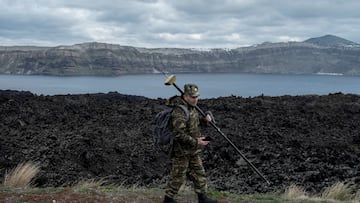Santorini island is seen in the background as a member of Greece¡¯s military geographical team proceeds to conduct geological measurements, to evaluate potential structural changes due to the ongoing seismic activity on the volcanic island of Nea Kameni, Greece, February 10, 2025. REUTERS/ Max Gyselinck