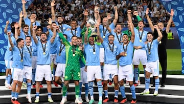 Manchester City's players celebrate on the podium after winning the 2023 UEFA Super Cup football match between Manchester City and Sevilla at the Georgios Karaiskakis Stadium in Piraeus on August 16, 2023. (Photo by Aris MESSINIS / AFP)