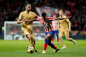 Sergio Busquets trata de evitar el avance de Reinildo Mandava.