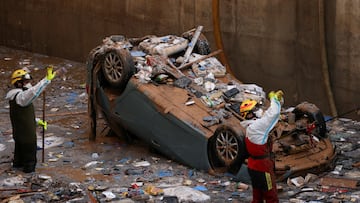 Firefighters work to remove a car from one of the exits of the Bonaire shopping centre car park, in Aldaia near Valencia, Spain, November 4, 2024. REUTERS/Nacho Doce