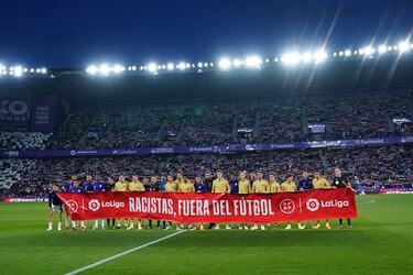 Los jugadores del Valladolid y Barcelona posan con una pancarta con el lema, 'Racistas, fuera del fútbol'.