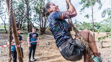 Participante agarrada a una cuerda de un obstáculo de la Bestial Race.