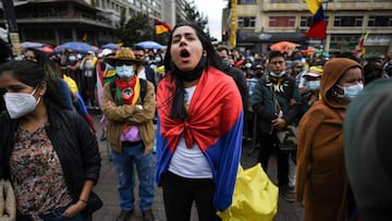 A demonstrator wrapped in a Colombian flag shouts slogans during a protest against the government of Colombian President Ivan Duque amid Independence Day celebrations in Bogota on July 20, 2021. (Photo by Juan BARRETO / AFP)