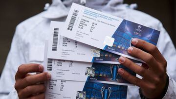 Un aficionado muestra cuatro entradas para la final de la Champions de 2016, que disputaron Real Madrid y Atl&eacute;tico en Mil&aacute;n.