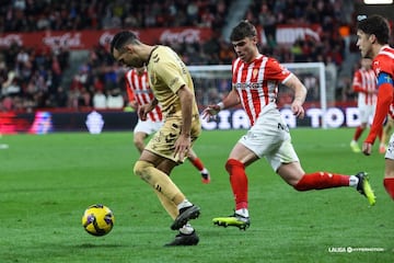 Pablo García persigue a un jugador del Málaga durante el partido en El Molinón.