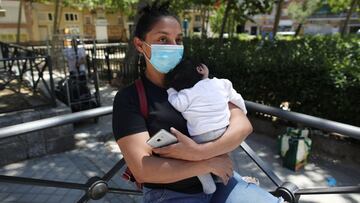 Lucía, una mujer con su bebé en brazos, acude a las puertas de la Parroquia Santa María Micaela para recibir una ayuda alimentaria.