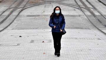 A woman wearing a face mask walks towards a light rail station in Sydney on June 23, 2021, as residents were largely banned from leaving the city to stop a growing outbreak of the highly contagious Delta Covid-19 variant spreading to other regions. (Photo