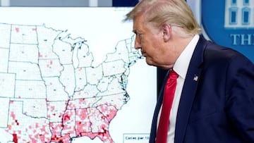 Donald Trump walks past a map of reported coronavirus cases as he departs following a Covid-19 briefing at the White House in Washington.