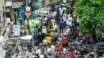 People gather for shopping from roadside vendors on a street, as a two-day lockdown is imposed every week across West Bengal state starting from July 23 to fight against the surge in COVID-19 coronavirus cases, in Kolkata on July 22, 2020. (Photo by Dibya