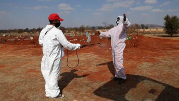 FILE PHOTO: Funeral workers wearing personal protective equipment sanitise each other after a burial amid a nationwide coronavirus disease (COVID-19) lockdown, at the Olifantsvlei cemetery, south-west of Joburg, South Africa July 28, 2020. REUTERS/Siphiwe