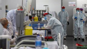 Imagen de varios profesionales sanitarios atendiendo a varios pacientes enfermos de coronavirus en un hospital.