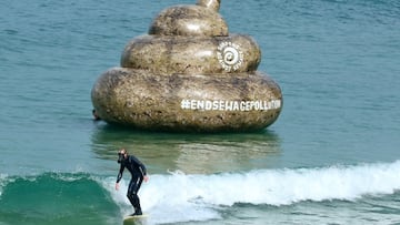Surfista con un excremento hinchable detrás