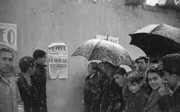 Aficionados haciendo cola bajo la nieve para asistir al partido entre el Real Racing Club y Atlético de Aviación, en el estadio Chamartín, en 1940.
