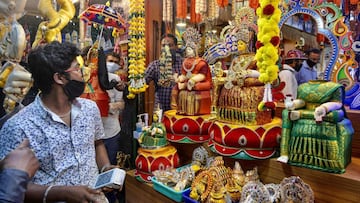 People shop for &#039;pooja&#039; (ritual) essentials at a store on the eve of &#039;Vara Mahalakshmi Vratha&#039;, a Hindu ritual held to appease the Goddess of wealth and prosperity Lakshmi, in Bangalore. 