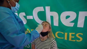 A healthcare worker conducts a polymerase chain reaction (PCR) Covid-19 test on a traveller at OR Tambo International Airport in Johannesburg on November 27, 2021, after several countries banned flights from South Africa following the discovery of a new Covid-19 variant Omicron. - A flurry of countries around the world have banned ban flights from southern Africa following the discovery of the variant, including the United States, Canada, Australia,Thailand, Brazil and several European countries. The main countries targeted by the shutdown include South Africa, Botswana, eSwatini (Swaziland), Lesotho, Namibia, Zambia, Mozambique, Malawi and Zimbabwe. (Photo by Phill Magakoe / AFP)