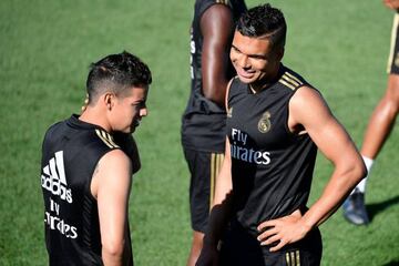 James Rodriguez talks with Real Madrid's Brazilian midfielder Casemiro during a training session.