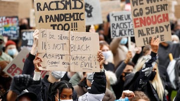 Demonstrators wearing protective face masks and face coverings hold placards during a Black Lives Matter protest in Manchester, following the death of George Floyd who died in police custody in Minneapolis, Manchester, Britain, June 6, 2020. REUTERS/Jason