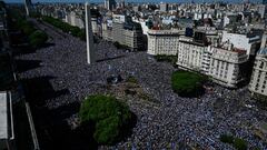 In this aerial view fans of Argentina wait for the bus with Argentina's players to pass through the Obelisk to celebrate after winning the Qatar 2022 World Cup tournament in Buenos Aires on December 20, 2022. - The airplane transporting World Cup winners Argentina and their captain Lionel Messi back from Qatar arrived at the Ezeiza international airport in Buenos Aires at 2:40 am (0540 GMT) on Tuesday. On midday Tuesday they will begin a tour through the Buenos Aires city center with millions expected out in the streets on what is a public holiday. (Photo by LUIS ROBAYO / AFP)